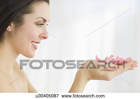 Studio shot of woman holding rose petals View Large Photo Image Stock Photo - Studio shot of woman holding rose petals. Fotosearch