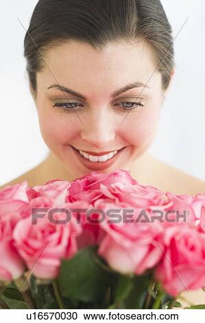 Studio shot of woman smelling roses View Large Photo Image Stock Image - Studio shot of woman smelling roses. Fotosearch