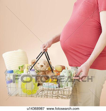 Studio shot of woman with shopping basket full of baby goods, midsection View Large Photo Image Stock Photo - Studio shot of woman with shopping basket full of baby goods, midsection. Fotosearch