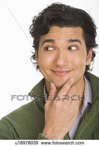 Stock Photo - Studio shot of young man looking surprised and happy. Fotosearch