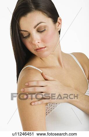 Stock Image - Studio shot of young woman caring for skin. Fotosearch