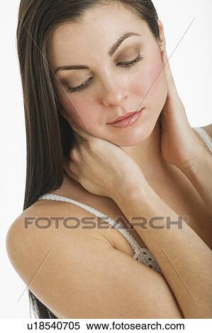 Stock Photography - Studio shot of young woman caring for skin. Fotosearch