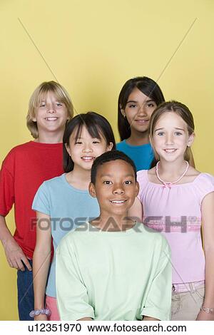 Stock Image - Studio shot portrait of five teenagers, waist up. Fotosearch