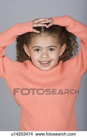 Picture - Studio shot portrait of girl with hands on head, waist up. Fotosearch