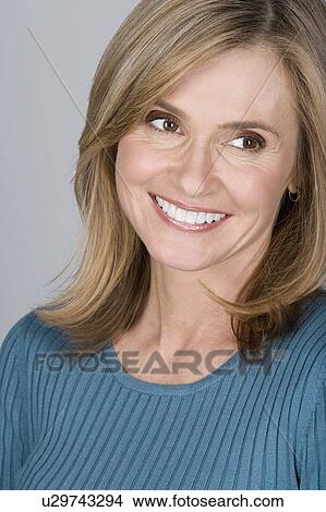 Picture - Studio shot portrait of mature woman looking away, head and shoulders. Fotosearch