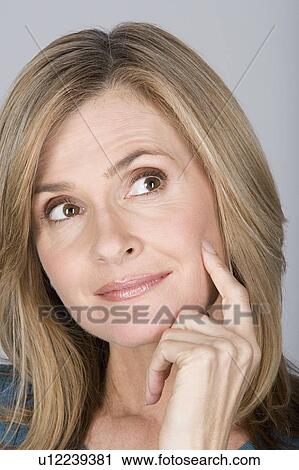 Studio shot portrait of mature woman with hand on chin, close-up View Large Photo Image Stock Image - Studio shot portrait of mature woman with hand on chin, close-up. Fotosearch