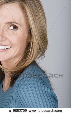 Stock Photo - Studio shot portrait of mature woman looking away, head and shoulders. Fotosearch
