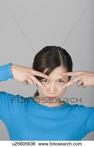 Stock Photograph - Studio shot portrait of mature woman with arms raised, head and shoulders. Fotosearch