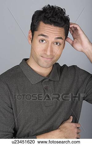 Stock Image - Studio shot portrait of mid adult man scratching head, head and shoulders. Fotosearch