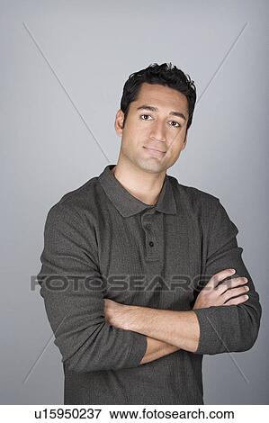 Stock Photo - Studio shot portrait of mid adult man with arms crossed, waist up. Fotosearch