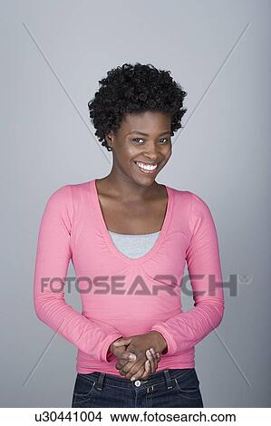 Picture - Studio shot portrait of mid adult woman with hands clasped, waist up. Fotosearch