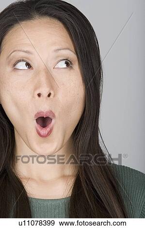 Stock Photo - Studio shot portrait of mid adult woman with mouth open. Fotosearch