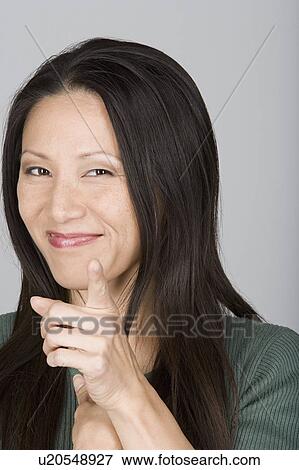 Studio shot portrait of mid adult woman pointing at viewer, head and shoulders View Large Photo Image Stock Photo - Studio shot portrait of mid adult woman pointing at viewer, head and shoulders. Fotosearch
