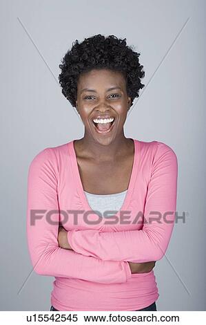 Stock Photography - Studio shot portrait of mid adult woman with arms crossed, waist up. Fotosearch