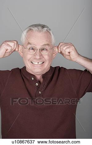 Studio shot portrait of senior man pulling his ears, head and shoulders View Large Photo Image Stock Photo - Studio shot portrait of senior man pulling his ears, head and shoulders. Fotosearch