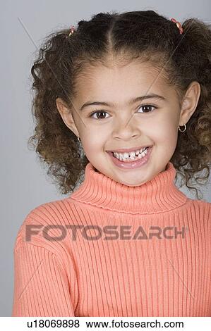 Stock Photo - Studio shot portrait of smiling girl, head and shoulders. Fotosearch