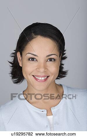 Stock Image - Studio shot portrait of smiling mid adult woman, close-up. Fotosearch
