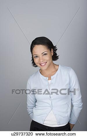 Stock Image - Studio shot portrait of smiling mid adult woman, waist up. Fotosearch