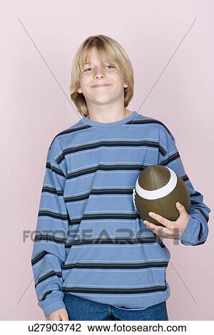 Studio shot portrait of teenage boy holding rugby ball, waist up View Large Photo Image Stock Image - Studio shot portrait of teenage boy holding rugby ball, waist up. Fotosearch
