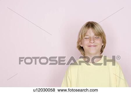 Stock Photo - Studio shot portrait of teenage boy with eyes closed, head and shoulders. Fotosearch