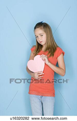 Studio shot portrait of teenage girl holding hart, three quarter length View Large Photo Image Stock Image - Studio shot portrait of teenage girl holding hart, three quarter length. Fotosearch
