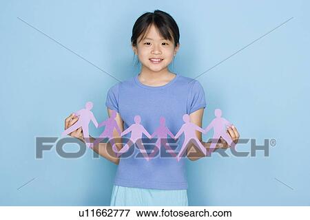 Stock Photo - Studio shot portrait of teenage girl holding paper chain, waist up. Fotosearch