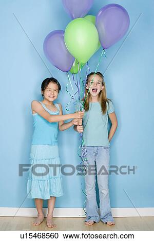 Studio shot portrait of two teenage girls holding balloons, full length View Large Photo Image Stock Image - Studio shot portrait of two teenage girls holding balloons, full length. Fotosearch