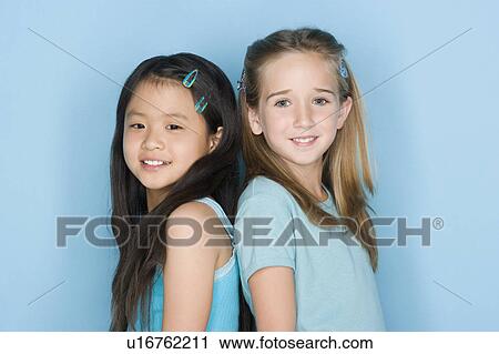 Studio shot portrait of two teenage girls standing back to back, head and shoulders View Large Photo Image Stock Image - Studio shot portrait of two teenage girls standing back to back, head and shoulders. Fotosearch