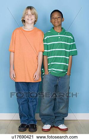 Stock Image - Studio shot portrait of two teenagers, full length. Fotosearch