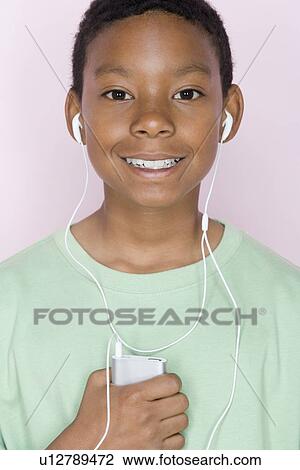 Stock Image - Studio shot portrait of young man with mp3 player, head and shoulders. Fotosearch