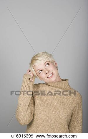 Studio shot portrait of young woman scratching head, waist up View Large Photo Image Stock Photography - Studio shot portrait of young woman scratching head, waist up. Fotosearch