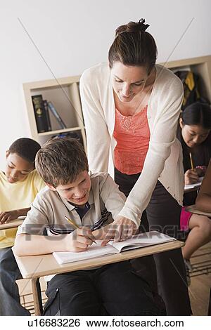 Teacher attending to schoolboy View Large Photo Image Stock Photograph - Teacher attending to schoolboy. Fotosearch