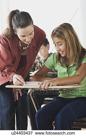Stock Photo - Teacher attending to schoolgirl. Fotosearch