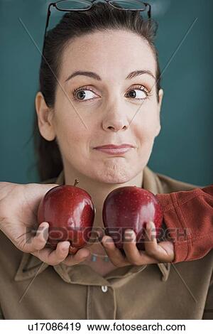 Stock Photo - Teacher being offered tow apples by pupils. Fotosearch