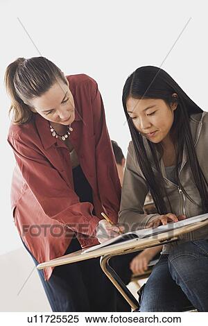 Teacher checking girl's homework View Large Photo Image Stock Photography - Teacher checking girl's homework. Fotosearch