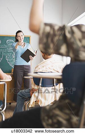 Stock Image - Teacher in classroom during lesson. Fotosearch