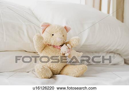 Teddy bear sitting on bed View Large Photo Image Stock Image - Teddy bear sitting on bed. Fotosearch