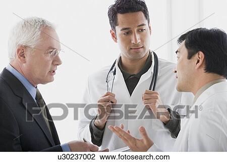 Three doctors discussing View Large Photo Image Stock Image - Three doctors discussing. Fotosearch