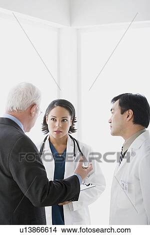 Three doctors in discussion View Large Photo Image Picture - Three doctors in discussion. Fotosearch