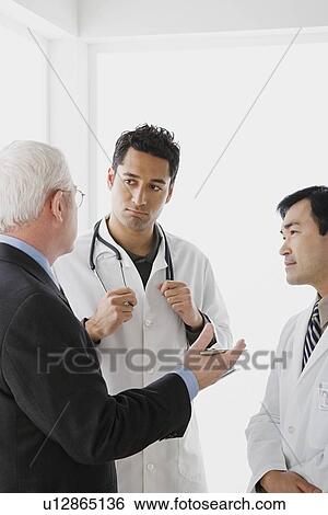 Stock Photograph - Three doctors in discussion. Fotosearch