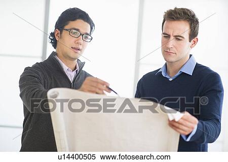 Stock Photography - Two businessmen discussing blueprint. Fotosearch