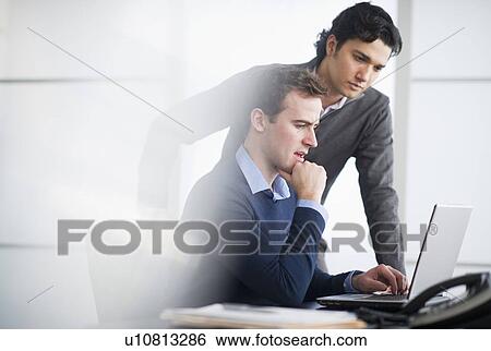 Two businessmen working with laptop View Large Photo Image Stock Photograph - Two businessmen working with laptop. Fotosearch