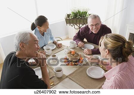 Stock Image - Two couples having coffee with cake. Fotosearch