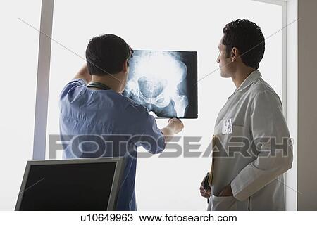 Stock Image - Two doctors looking at x-ray image. Fotosearch
