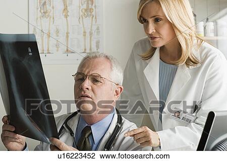 Stock Image - Two doctors looking at x-ray image. Fotosearch