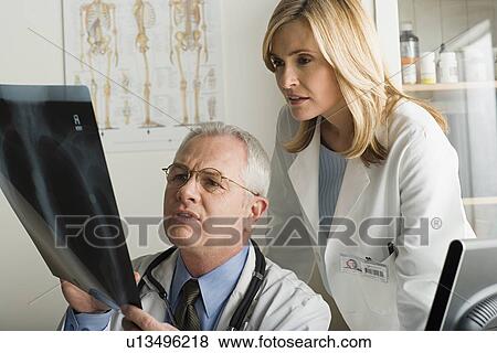 Two doctors looking at x-ray image View Large Photo Image Stock Photo - Two doctors looking at x-ray image. Fotosearch