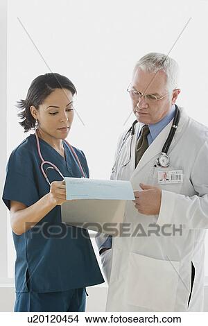 Two doctors reading document View Large Photo Image Picture - Two doctors reading document. Fotosearch