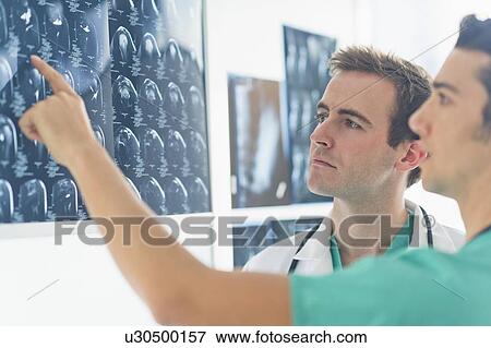 Stock Photo - Two male doctors discussing x-ray images. Fotosearch