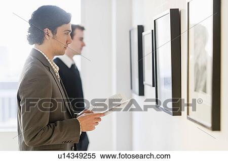 Stock Photography - Two men working in art gallery. Fotosearch
