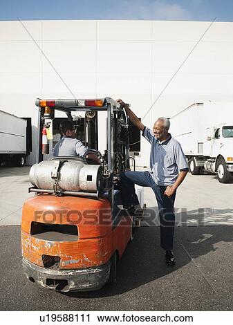 Stock Image - Two men working with forklift. Fotosearch